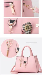 Close-up of pink textured leather handbag with gold zipper and bear heart charms