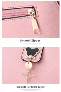 Detail of pink pebbled leather handbag with gold zipper and cartoon shaped hardware