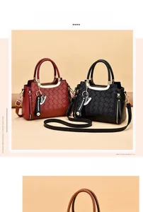 Detail of woven lattice pattern handbag with gold circular metal handle and pendant