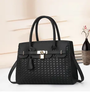 Détail du sac cabas noir à texture tressée avec pendentif cadenas et clé doré