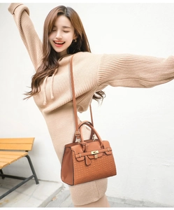 Détail d'un sac bandoulière marron texturé avec garnitures dorées en décor extérieur