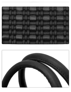 Détail de la texture en cuir noir tressé et poignée robuste avec des coutures précises