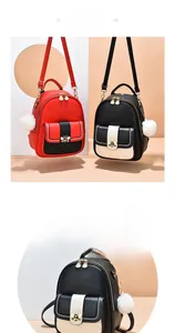 Detail of mini backpack featuring contrast colors, bee charm and white faux fur pompom