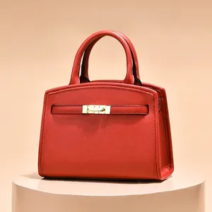 Sac à main minimaliste en cuir rouge avec finitions texturées et fermoir doré chic