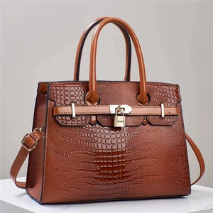 Close-up of the lizard texture and golden padlock detail on this brown handbag