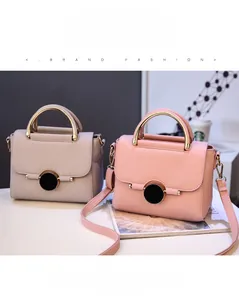 Detail of lychee pattern leather handbag with round black clasp and metal handle