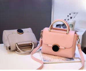 Detail of pink and grey faux leather handbags with metal ring clasps and top handles