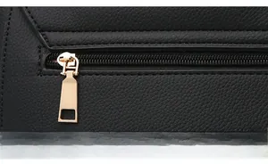 Close-up of golden hardware zipper on black litchi pattern leather shoulder bag