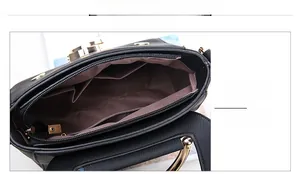Detail view of the black lychee leather handbag interior with brown lining and gold zippers
