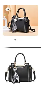 Detail of black leather handbag featuring white stitching and leopard print silk scarf