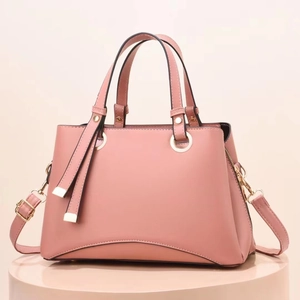 Dettaglio della borsa rosa in pelle martellata con finiture dorate e cerniera laterale