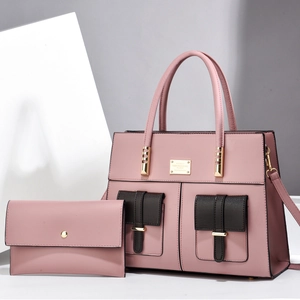 Pink tote bag detail with brown pockets, gold hardware and matching envelope clutch bag