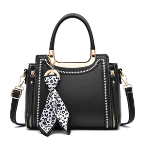 Black faux leather tote bag with white contrast embroidery and leopard print silk scarf