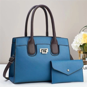 Bolso azul oscuro de cuero litchi con asas marrones y cierre giratorio de plata elegante