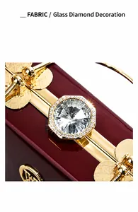 Detail view of large hexagonal glass diamond on red patent leather evening clutch bag