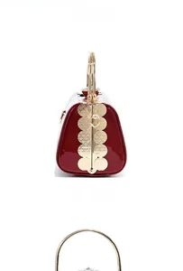 Detailed side view of glossy burgundy patent leather evening bag with gold ring handle