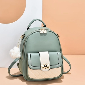 Green leather backpack for women with gold bee emblem and quilting in studio setting