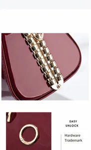 Detail der dunkelroten Lackleder Abendtasche mit goldener Nietschließe und Metallteilen