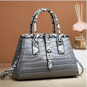 Detail der grauen Krokodil-Struktur Tasche mit Schlangenprint-Griff und Metallschloss