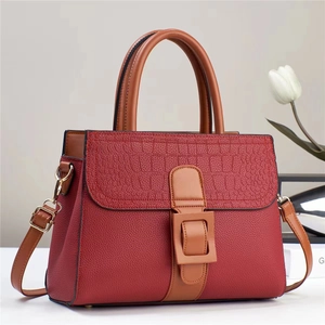 Close-up of contrast leather texture and crocodile embossed flap on tote bag