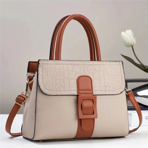 Detail view of the contrast beige crocodile texture and pebble leather on the shoulder bag