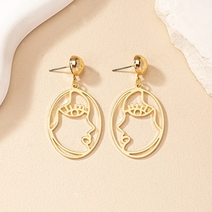 Boucles d'oreilles dorées silhouette visage abstrait avec cadre métallique ovale élégant