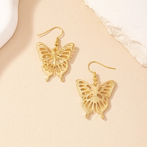 Close-up of golden hollow butterfly drop earrings with detailed wing texture and elegant finish