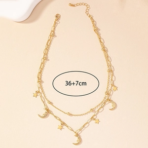 Détail du collier doré double épaisseur avec pendentifs étoiles et lunes, longueur 36+7cm