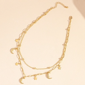 Détail d'un collier doré multi-rangs avec pendentifs étoile et lune et fermoir homard
