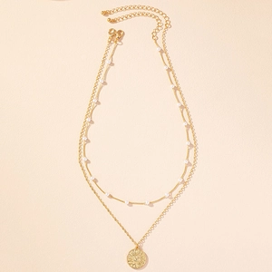 Collana a doppio strato dorata con piccole perle bianche e ciondolo a rilievo sole