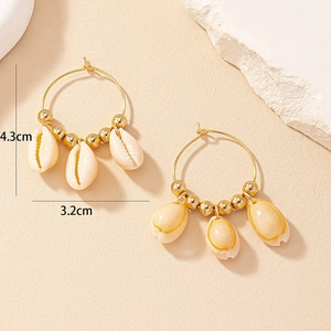 Détail de boucles d'oreilles bohèmes avec coquillages, mesure 4,3 cm de haut et 3,2 cm de large