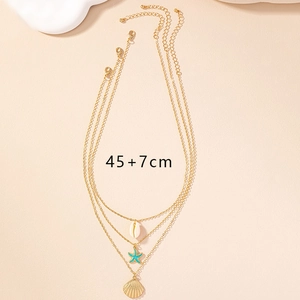 Detailed view of layered gold necklace with seashell, starfish pendants and 45+7cm sizing