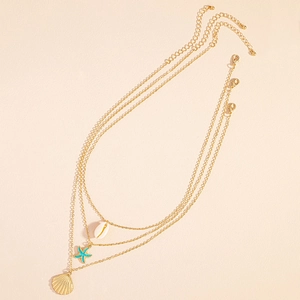 Three-layer gold necklace featuring starfish pendant, scallop shell and seashell charms