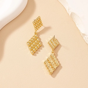 Detail of gold geometric rhombus earrings with intricate beaded texture and layered design