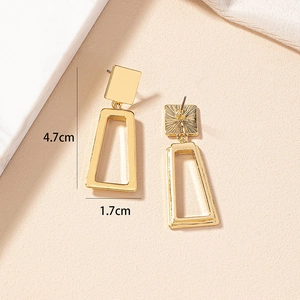 Detail of geometric gold earrings showing polished front and textured back surface