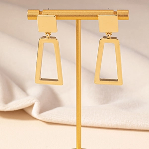 Minimalist geometric square and trapezoid gold dangle earrings on a jewelry stand
