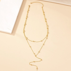 Elegant gold multi-layer Y-shaped tassel necklace with small round beads on plain background