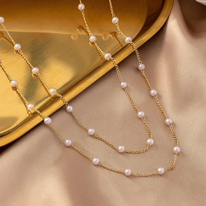 Elegant gold chain necklace with freshwater pearls on a luxurious silk background