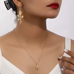 Elegant gold rose flower necklace and earring jewelry set shown on a female model