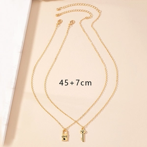 Détail du collier doré avec pendentif cadenas d'amour et clé incluant une chaîne d'extension