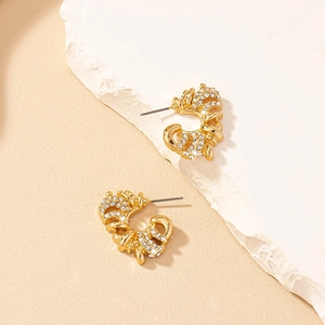 Chic gold-toned C-shape earrings with twisted texture and pave rhinestones on stone base