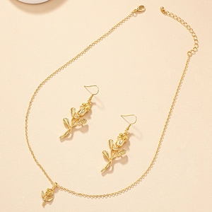 Detailed view of the gold rose pendant necklace and matching earrings jewelry set