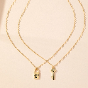 Vue détaillée des pendentifs cadenas et clé dorés avec gravure LOVE sur des colliers