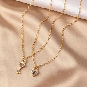 Collier élégant en or avec pendentifs clé et cadenas cœur étincelants sur soie
