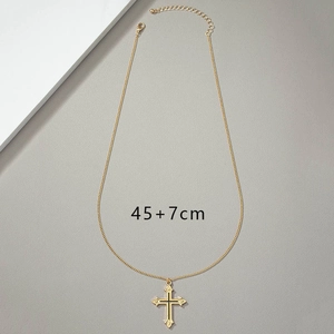 Flat lay of gold cross pendant necklace with 45cm main chain and 7cm extension