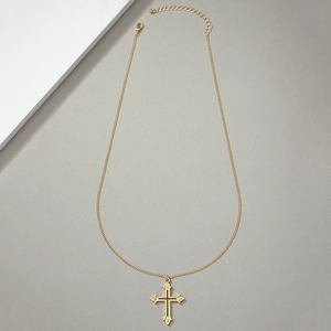 Detail of gold cross pendant with black accents and lobster clasp on fine O-chain
