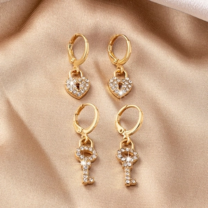 Boucles d'oreilles huggie luxe dorées cœur et clé avec pavé de cristaux étincelants