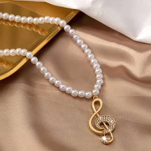 Elegant pearl necklace with a sparkling gold treble clef musical note pendant for women