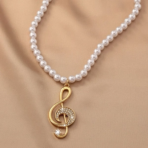Detail of music note pendant necklace with freshwater pearls and sparkling crystals