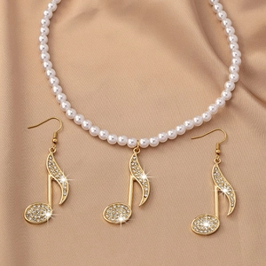Vue macro d'un ensemble de bijoux notes de musique serti de cristaux sur satin soyeux